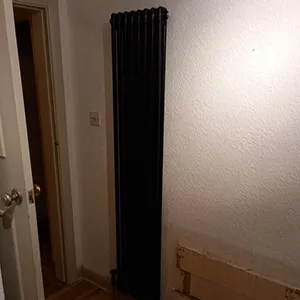 A bathroom with a radiator next to a door.
