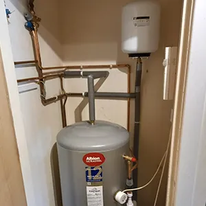 A water heater in the corner of a room.