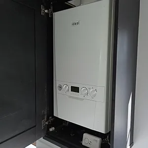 A tankless water heater sitting inside of a cabinet.