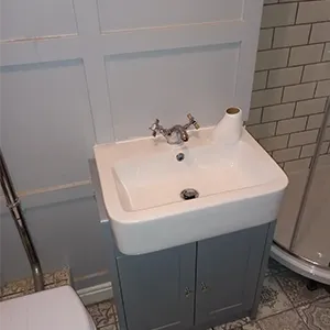 A bathroom with a toilet, sink and shower.